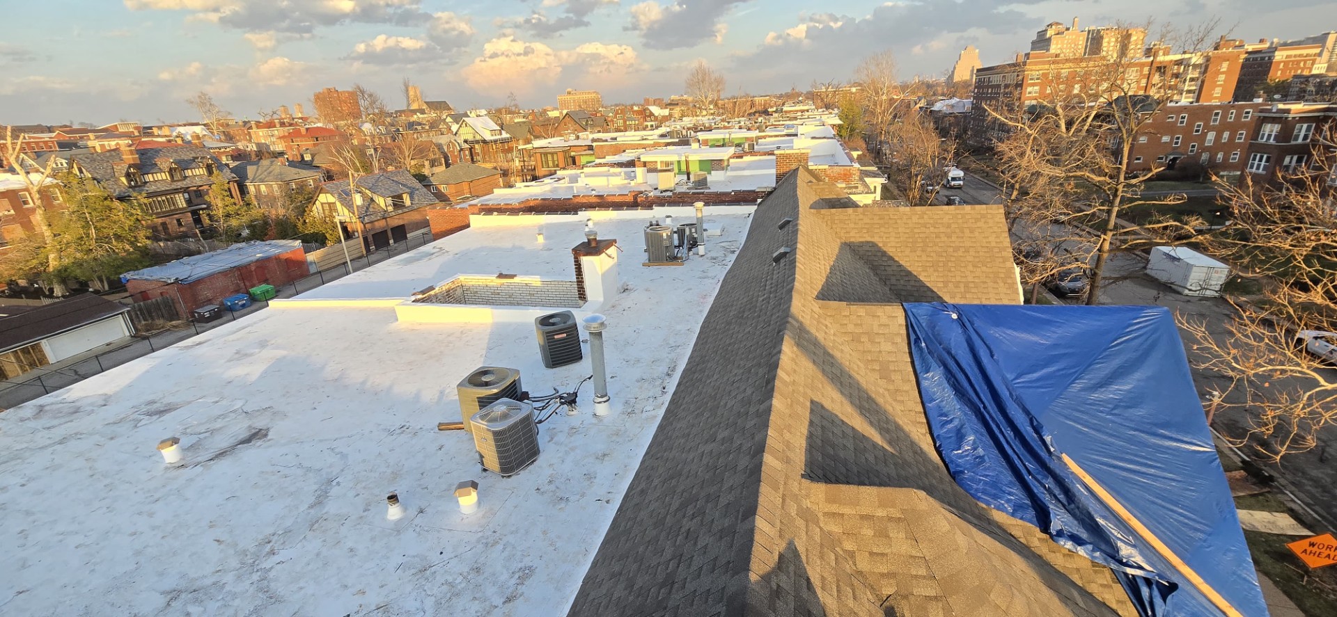 Aerial drone shot of a freshly installed white TPO roof on a long commercial building