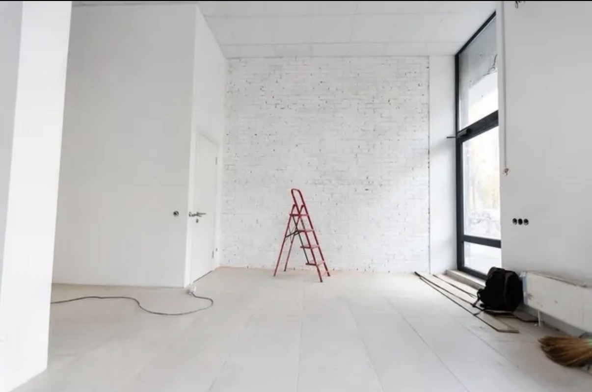 Amigo drywall finishing in a commercial interior, fresh white walls and a painted brick accent